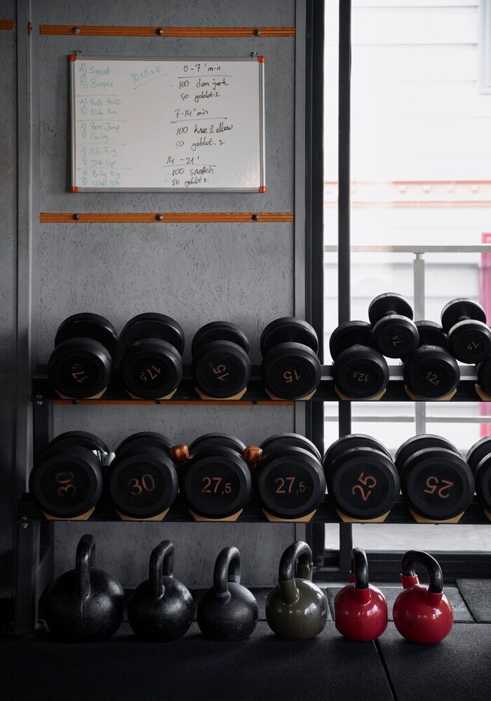 a weight rack from the gym with dumbells on it